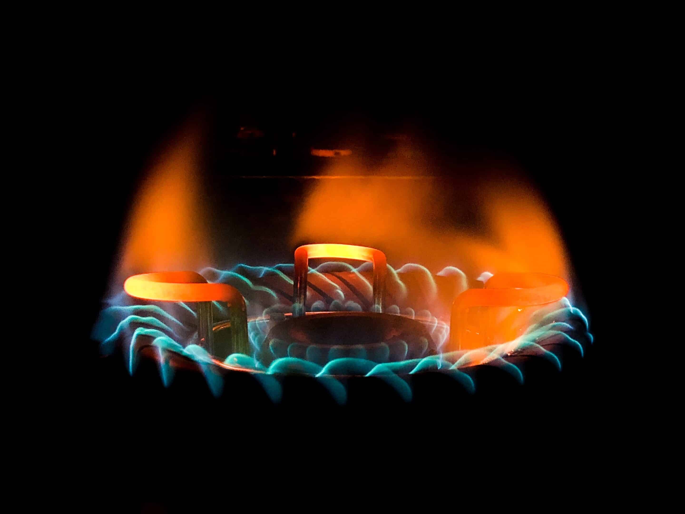 Closeup shot of a beautiful blue-green flame in a gas stove rouge